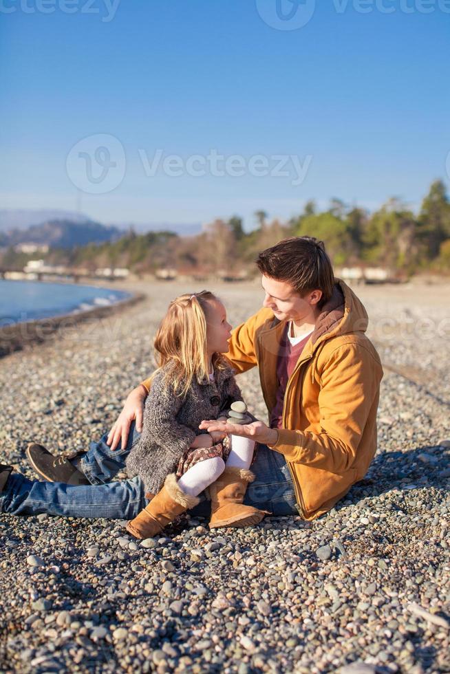 jeune père et petite fille à la plage par une journée d'hiver ensoleillée photo