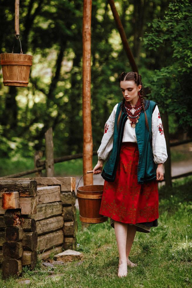 fille ukrainienne aux pieds nus porte de l'eau photo