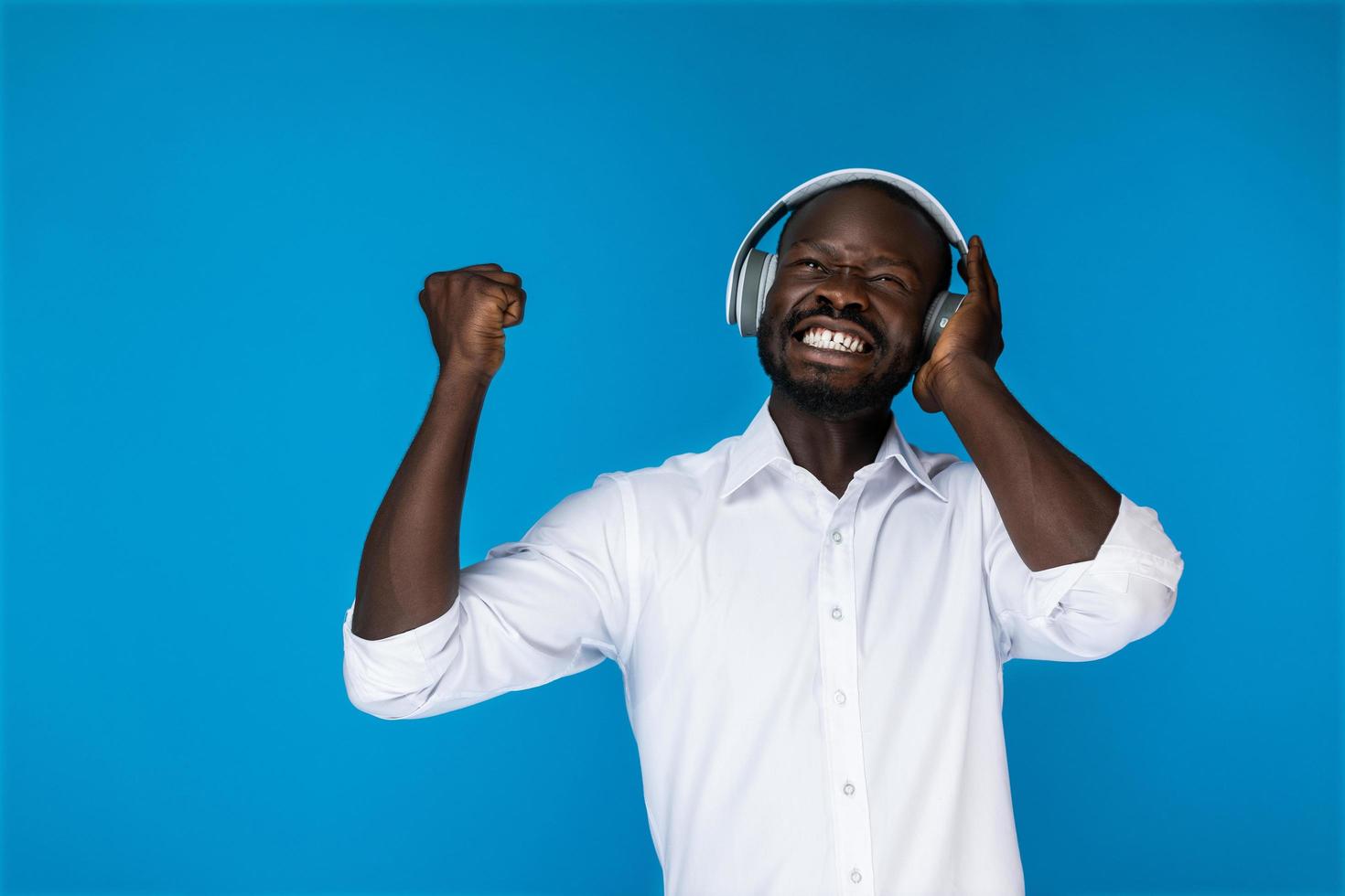 un homme satisfait écouter de la musique dans les écouteurs photo