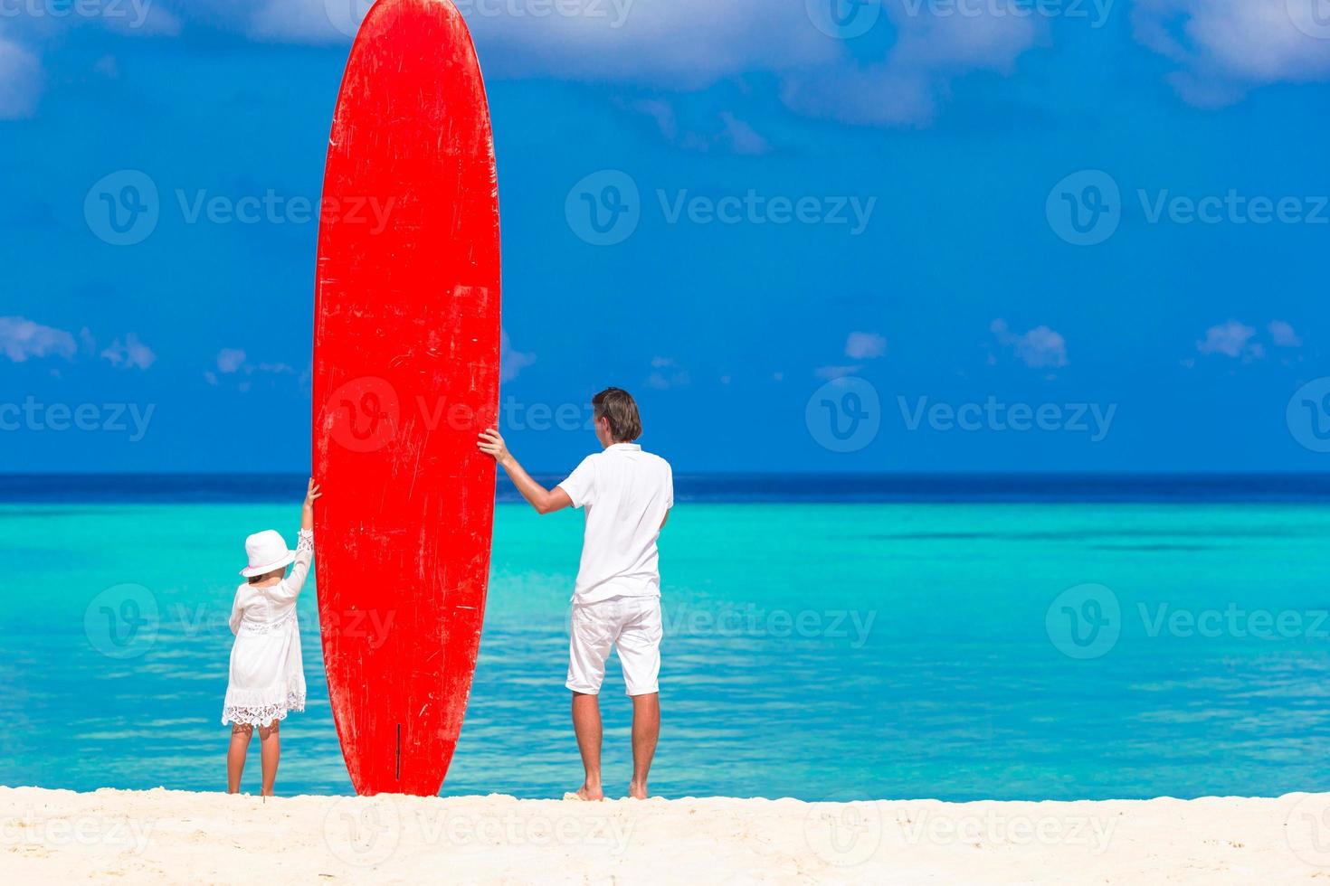 père et son enfant avec planche de surf pendant les vacances d'été photo