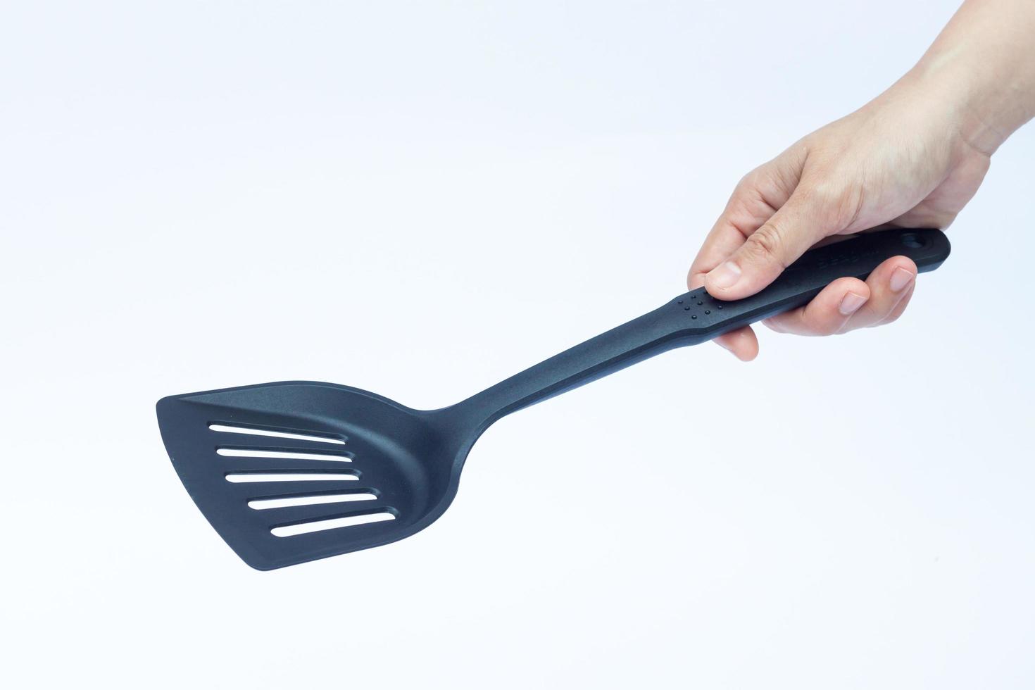 main tenant une spatule sur fond blanc photo