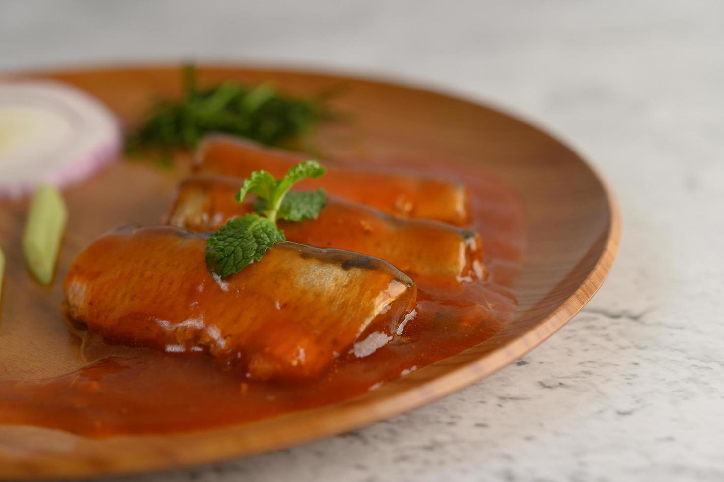 Salade de sardines épicées sur une assiette en bois photo