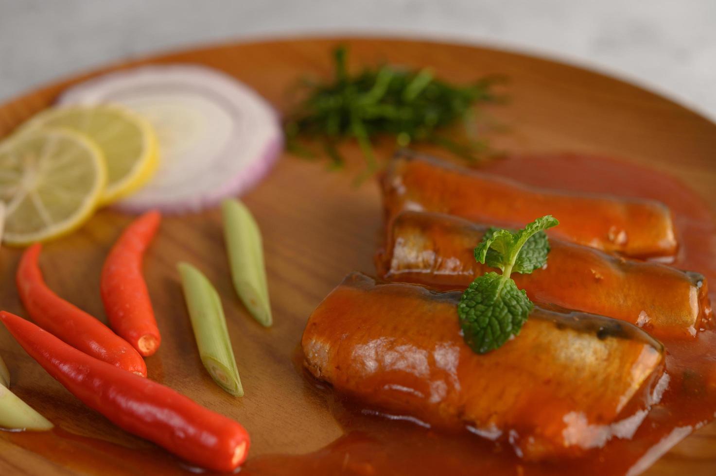 Sardines à la sauce tomate sur un plateau en bois photo