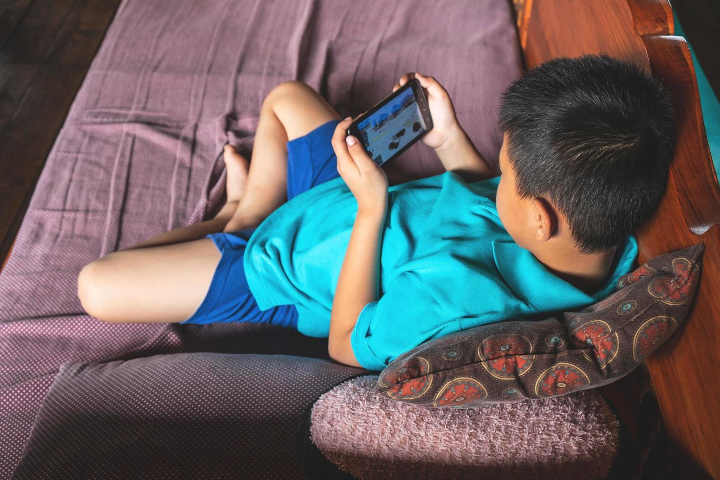 garçon jouant à des jeux sur un téléphone photo