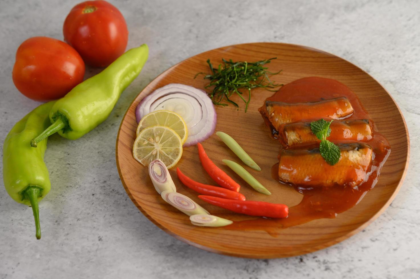 Salade de sardines épicées sur une assiette en bois photo