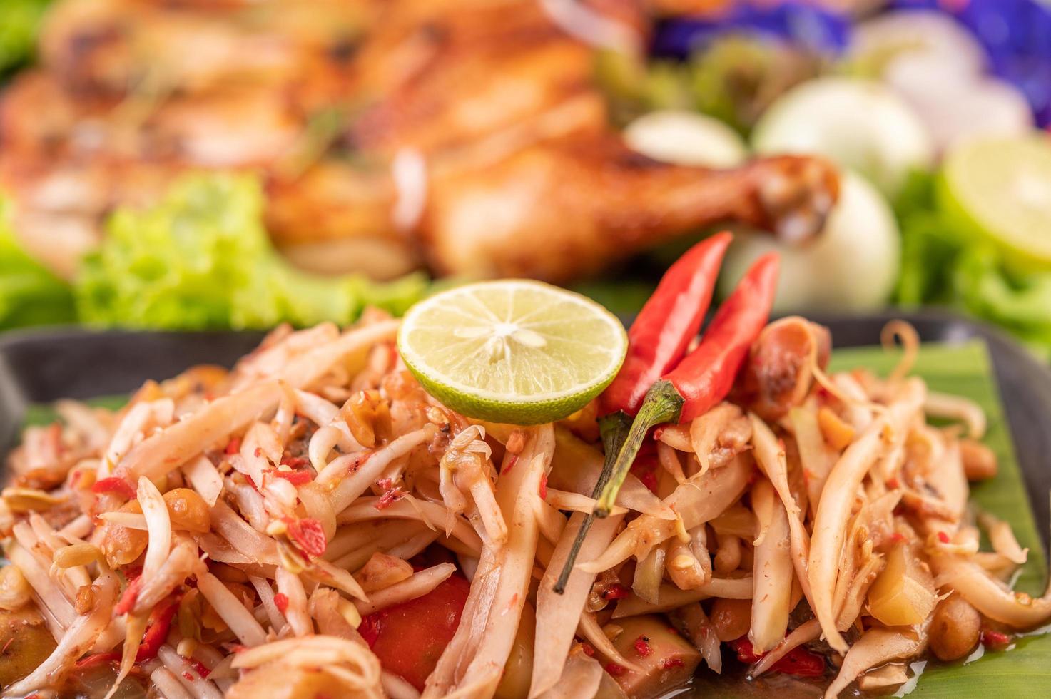 salade de papaye thaï entourée de légumes et de poulet photo