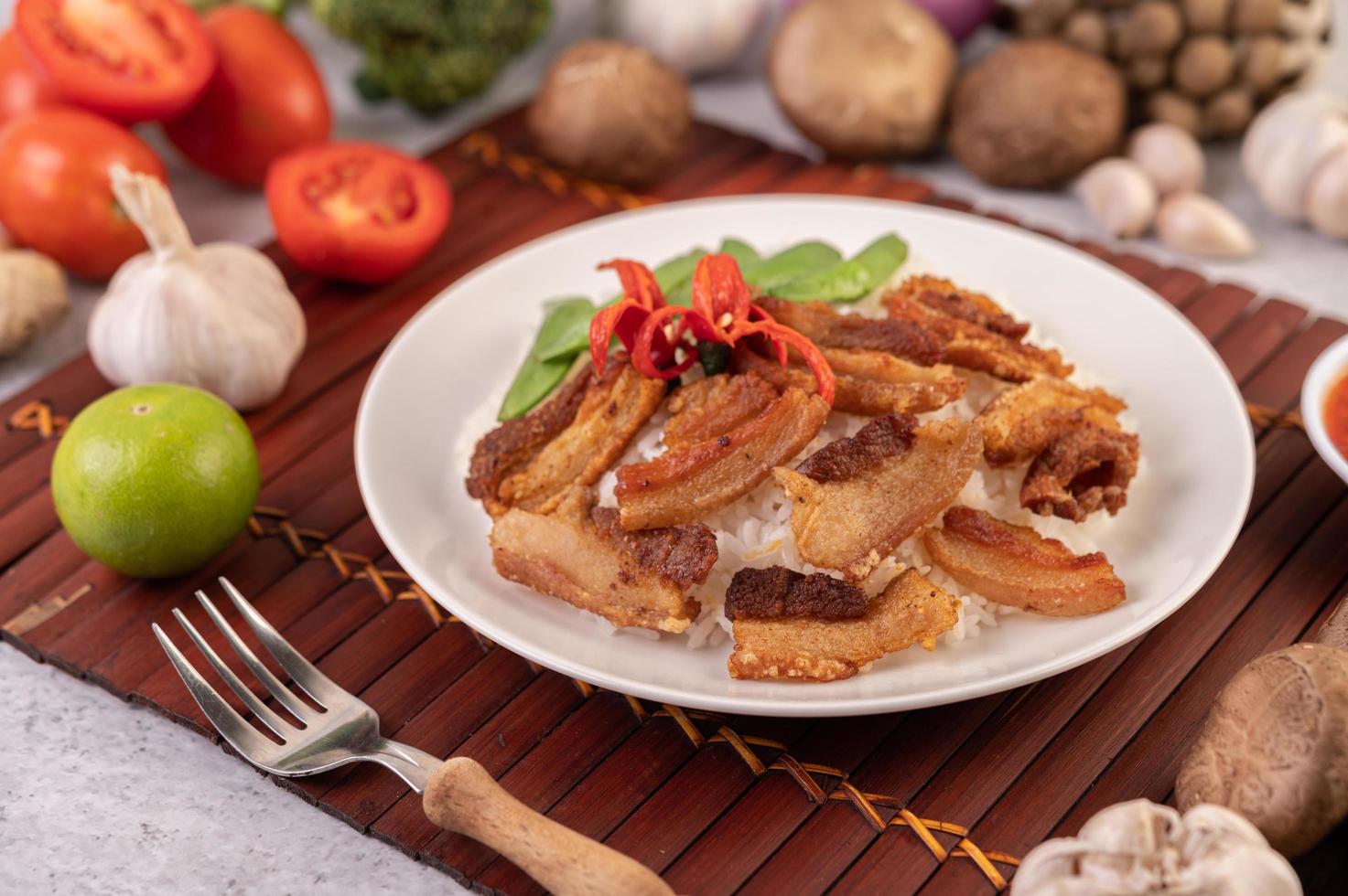 Poitrine de porc sur riz coulé aux légumes photo