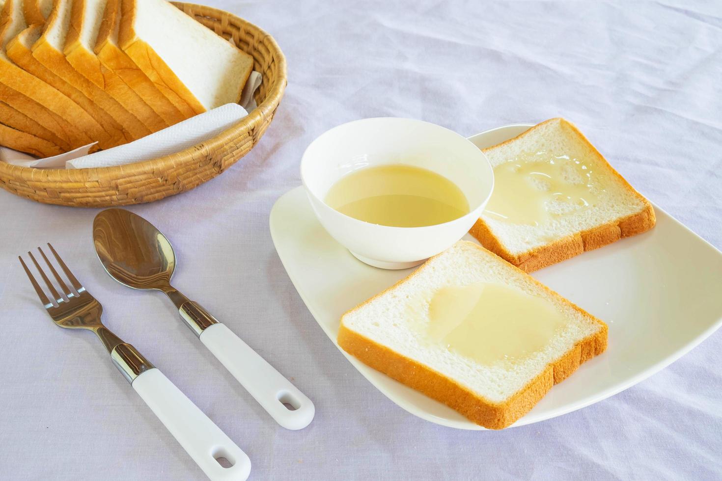 pain et lait concentré sucré sur une assiette photo