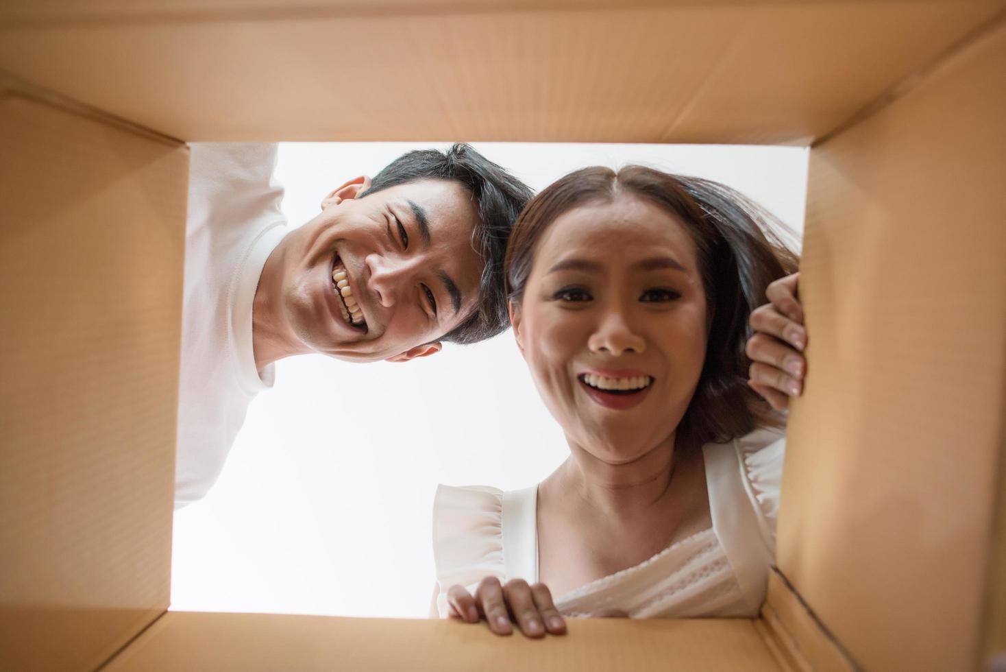 couple heureux ouvrant une boîte et regardant à l'intérieur photo