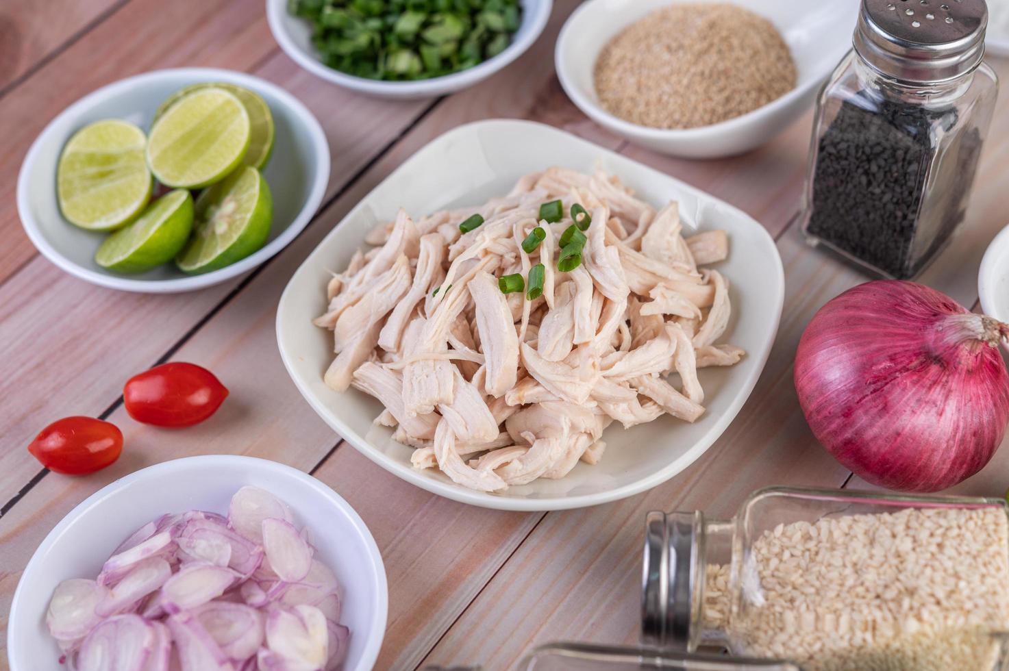 Morceaux de poulet bouilli avec légumes et épices sur une table en bois photo