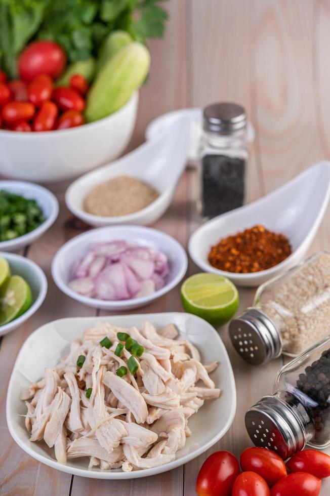 Morceaux de poulet bouilli avec légumes et épices sur une table en bois photo