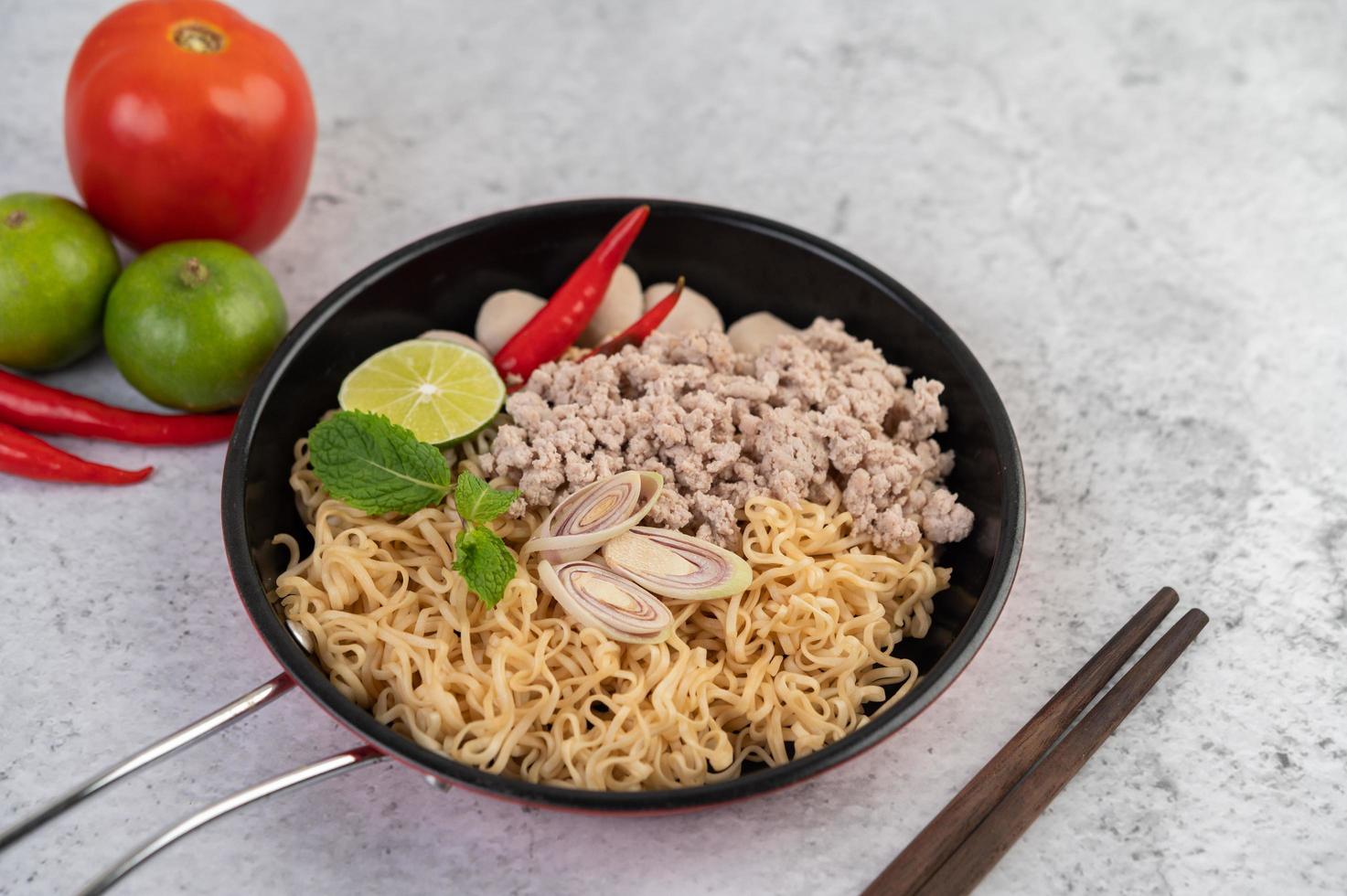 porc haché dans une poêle avec de la lime, des piments et des boulettes de viande photo