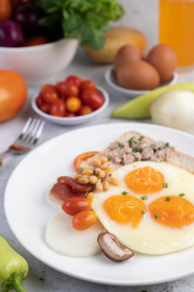œufs au plat, saucisses, porc haché, pain et haricots rouges photo