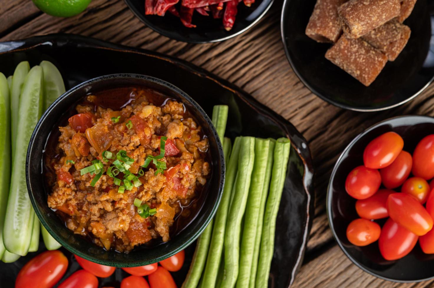 bol de porc sucré avec concombres, haricots longs et tomates photo