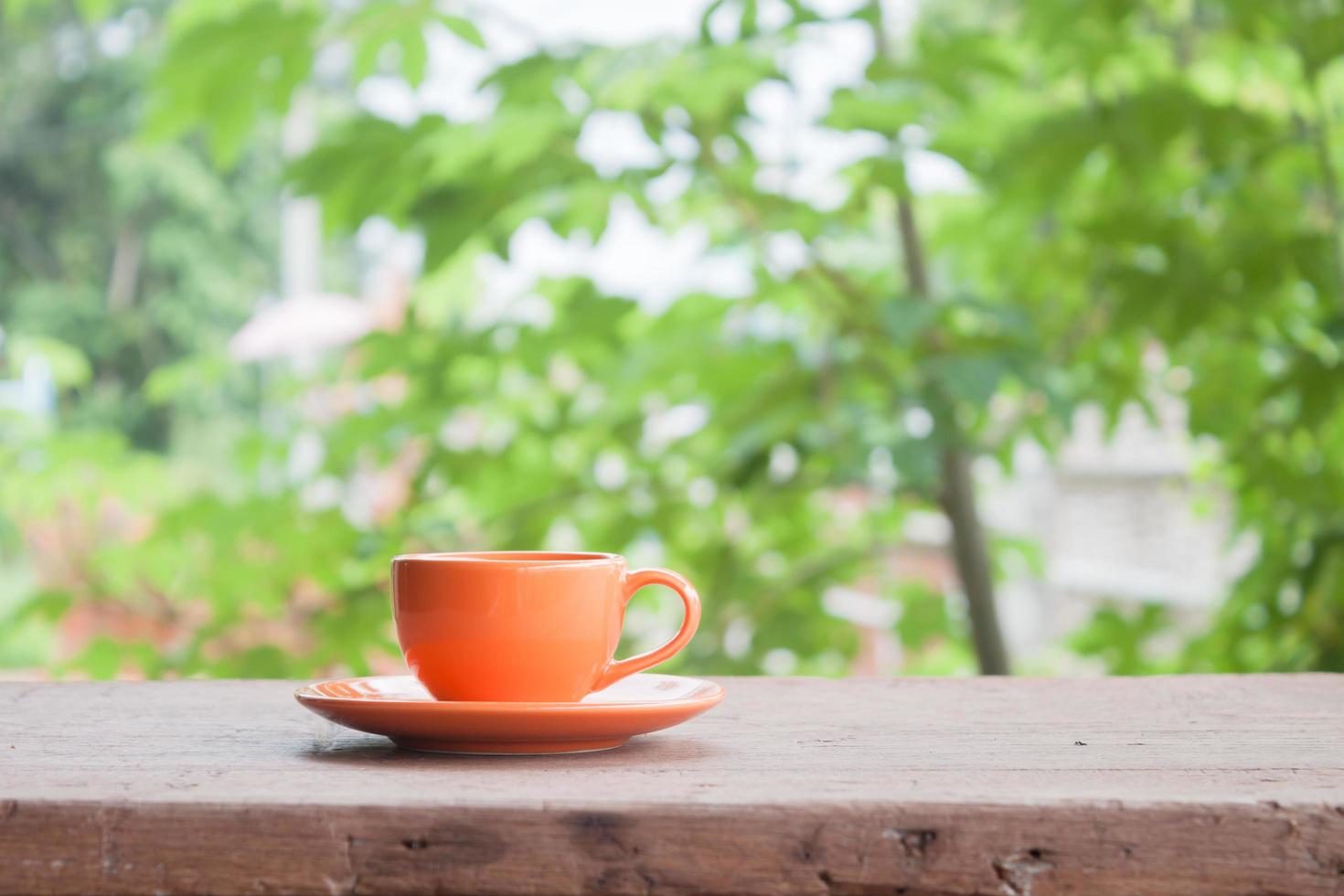 tasse orange sur une table à l'extérieur photo