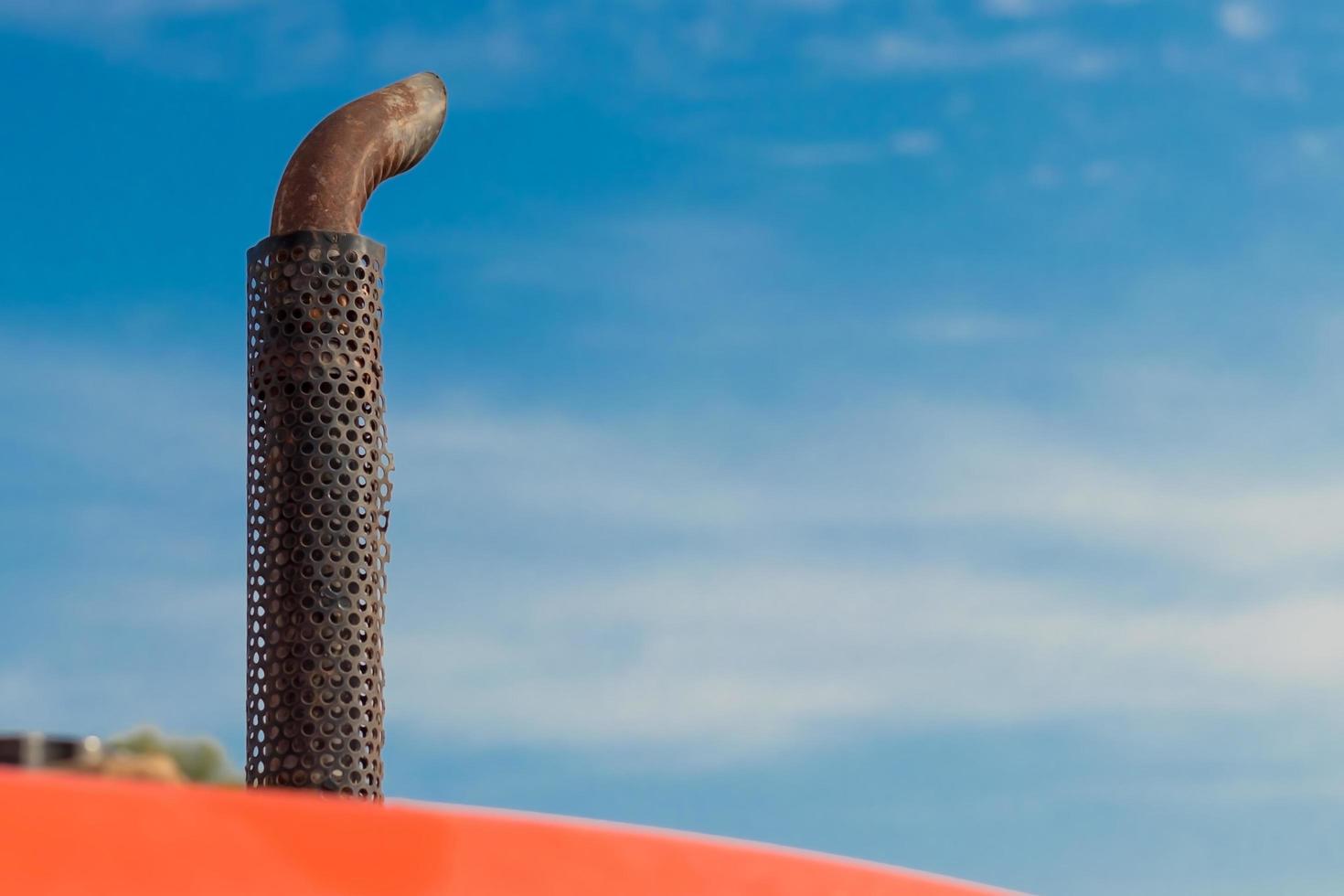 tuyau d'échappement d'un tracteur avec un ciel bleu. photo