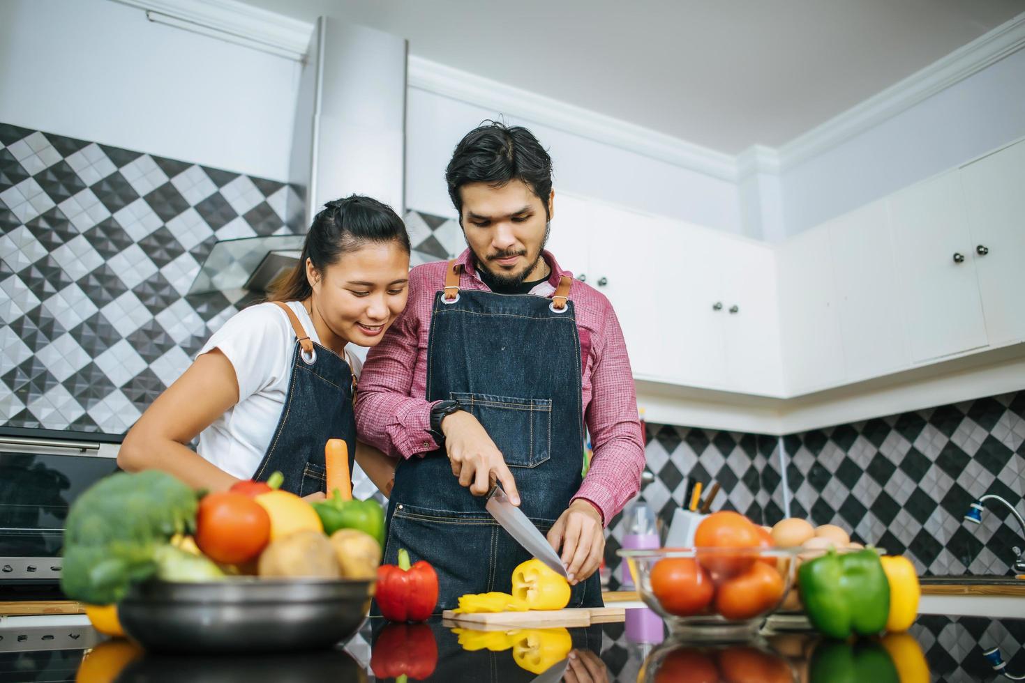 heureux, jeune couple, préparer, nourriture, pour, cuisine, dans, cuisine, chez soi photo