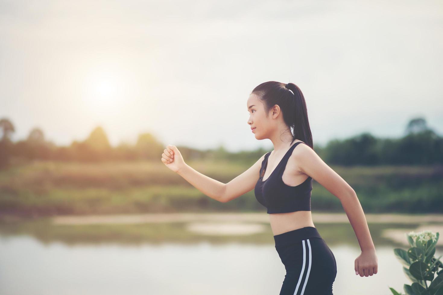 Une jeune coureuse heureuse jogging à l'extérieur photo