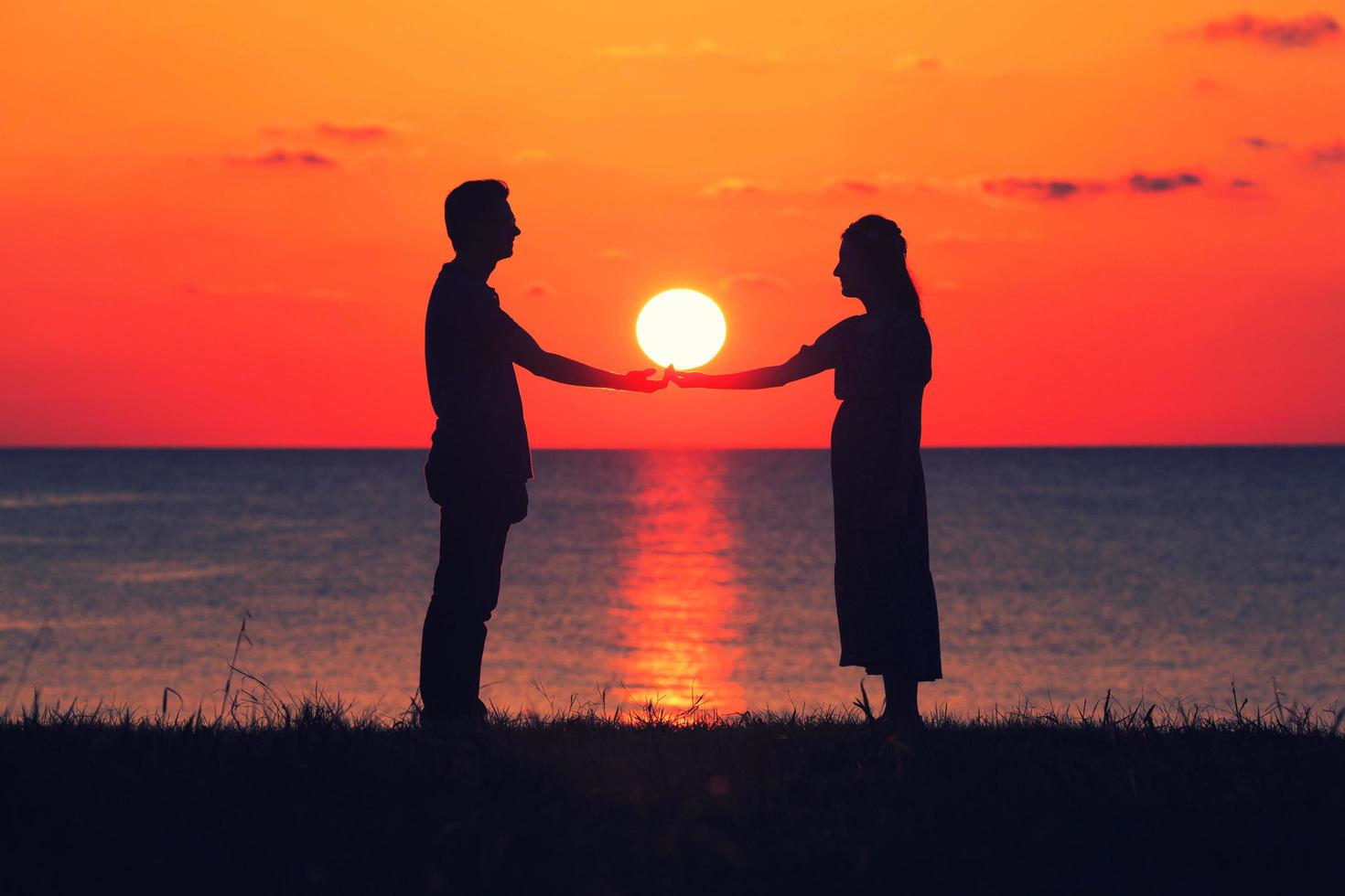 deux personnes se tenant la main au coucher du soleil photo