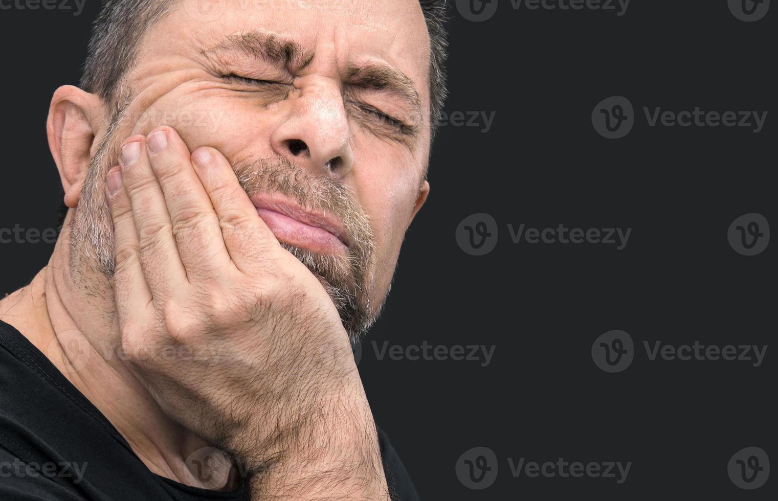 mal aux dents. homme avec le visage fermé à la main photo