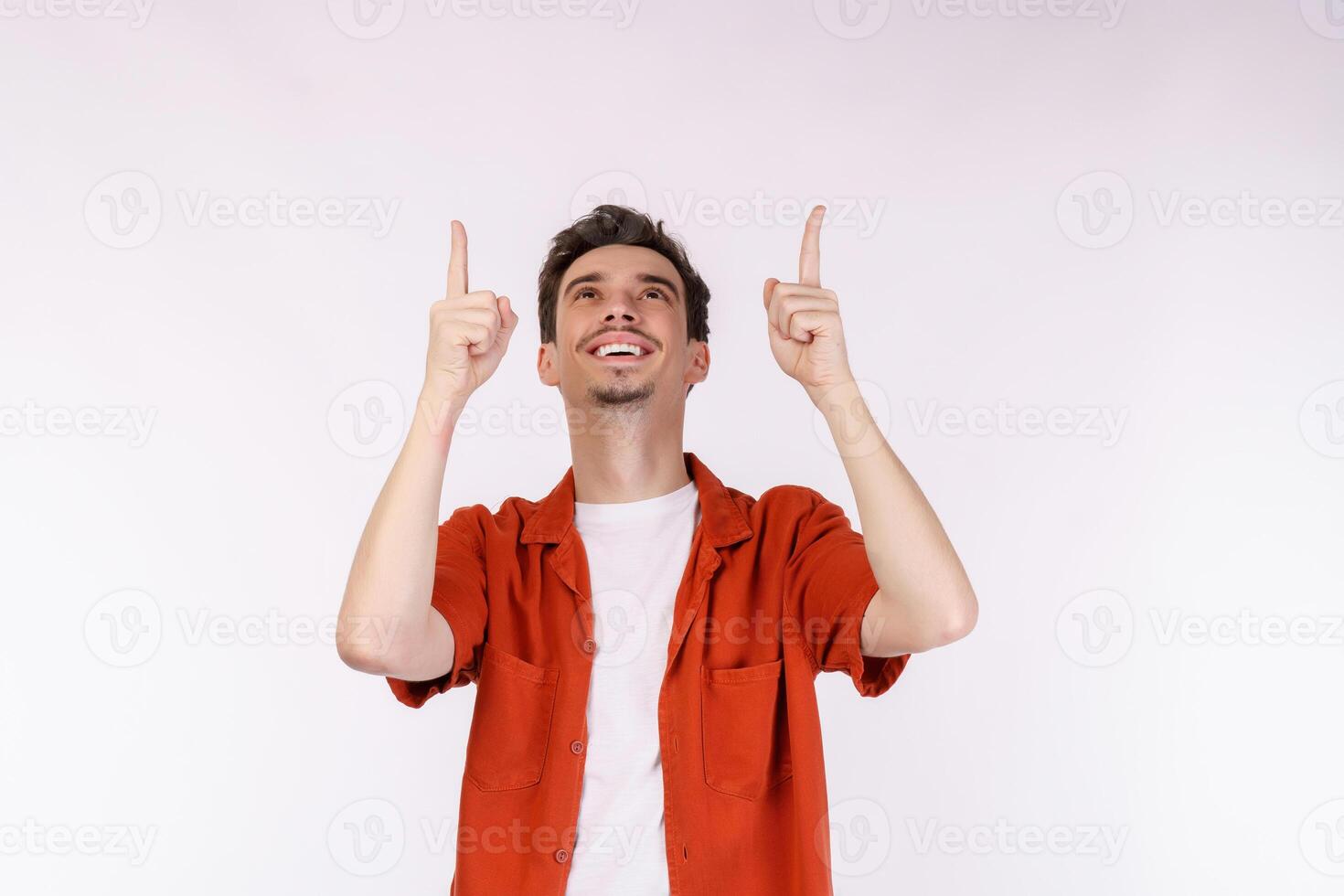 portrait de jeune homme pointant du doigt l'espace de copie isolé sur fond de studio blanc photo