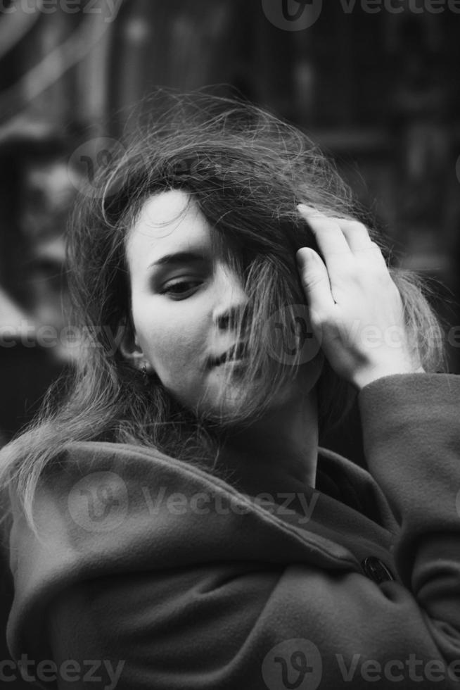 Close up positive femme ajustant les cheveux sur la rue photo portrait monochrome