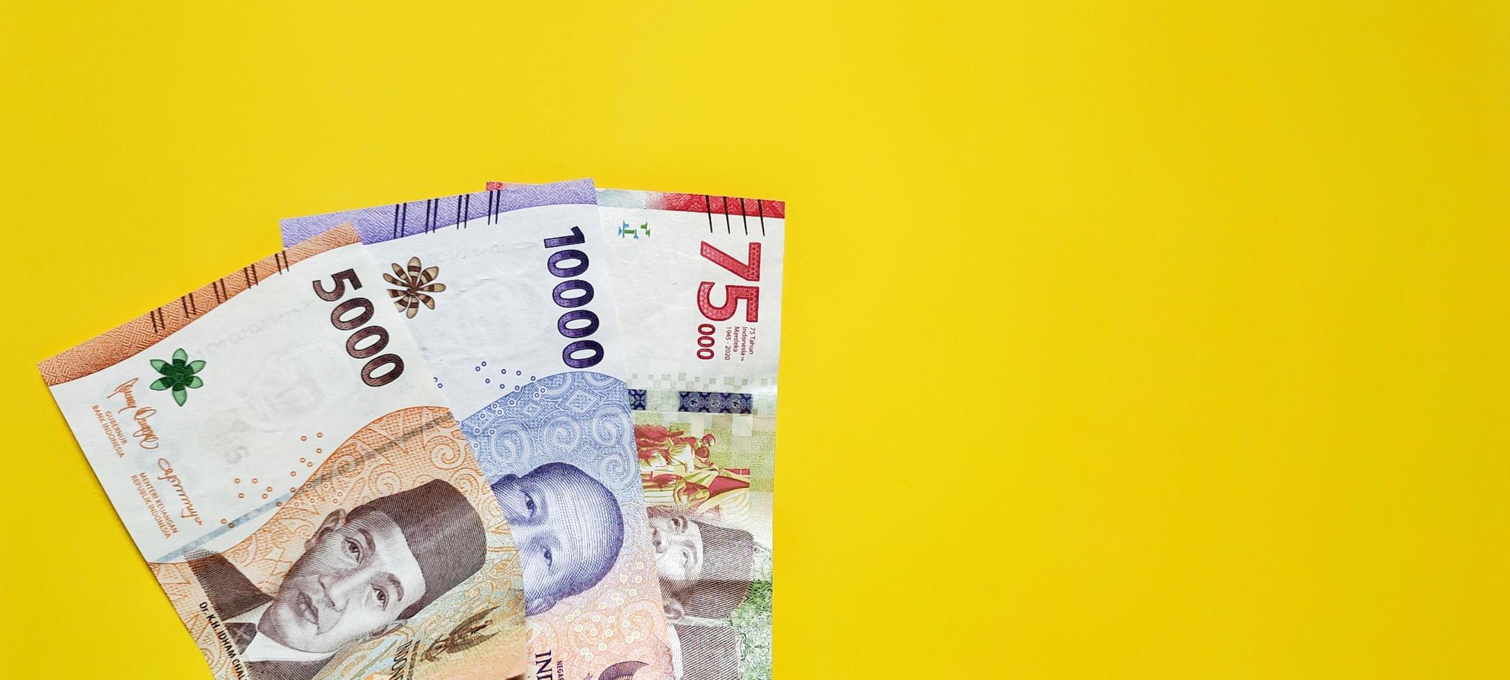 nouveaux billets indonésiens isolés sur fond jaune, espace négatif. photo