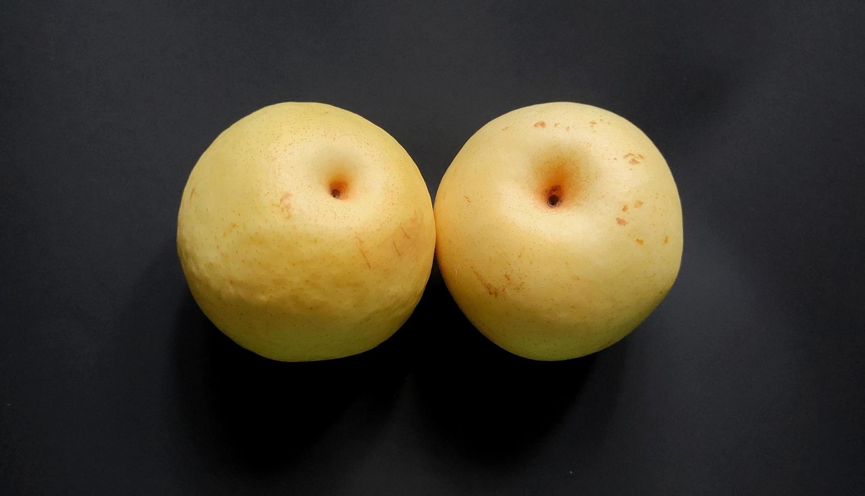 deux poires fruits isolés par fond noir. photo