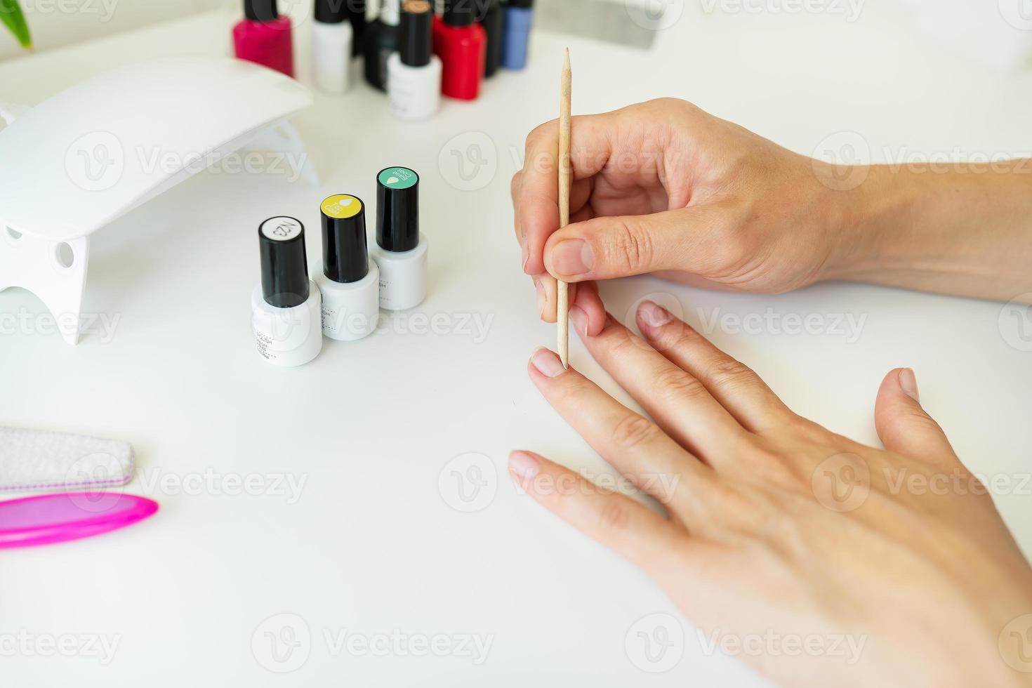 couvrant vos ongles avec du vernis gel à la maison, votre propre maître, nettoyez les cuticules. soins des mains professionnels, spa à domicile. photo