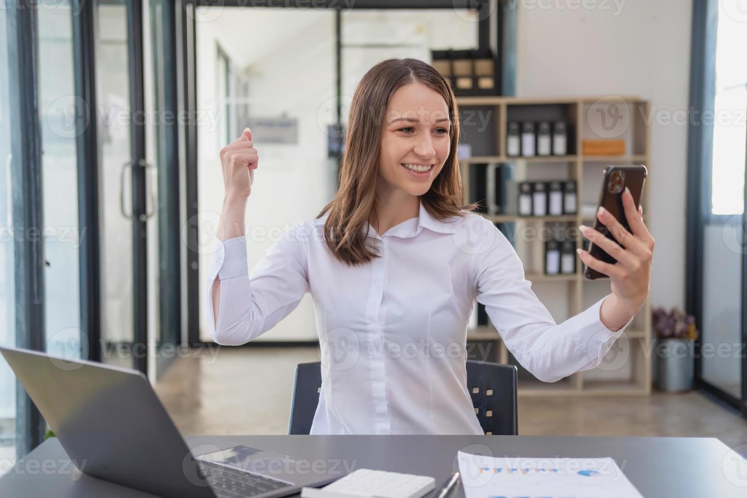 marketing, finance, comptabilité, planification. femme d'affaires caucasienne tenant un téléphone portable et faisant preuve de bonne volonté chez le client rejoignant l'entreprise pour augmenter les bénéfices du bureau et des documents pour ordinateur portable photo