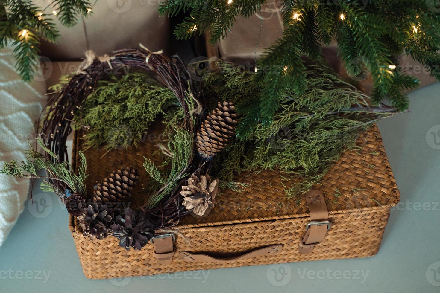 valise en osier décorée de branches d'épicéa et d'un cône .décoration de la maison de noël photo