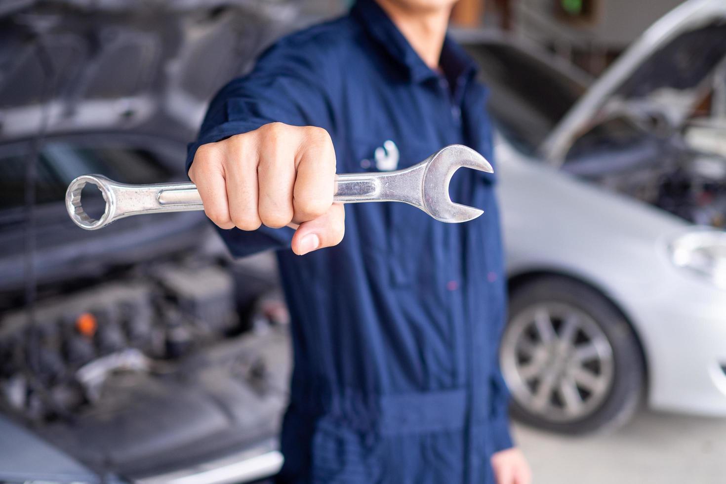 le mécanicien porte un uniforme et a un tournevis. concept de service de voiture, réparation, entretien, prêt à entretenir photo