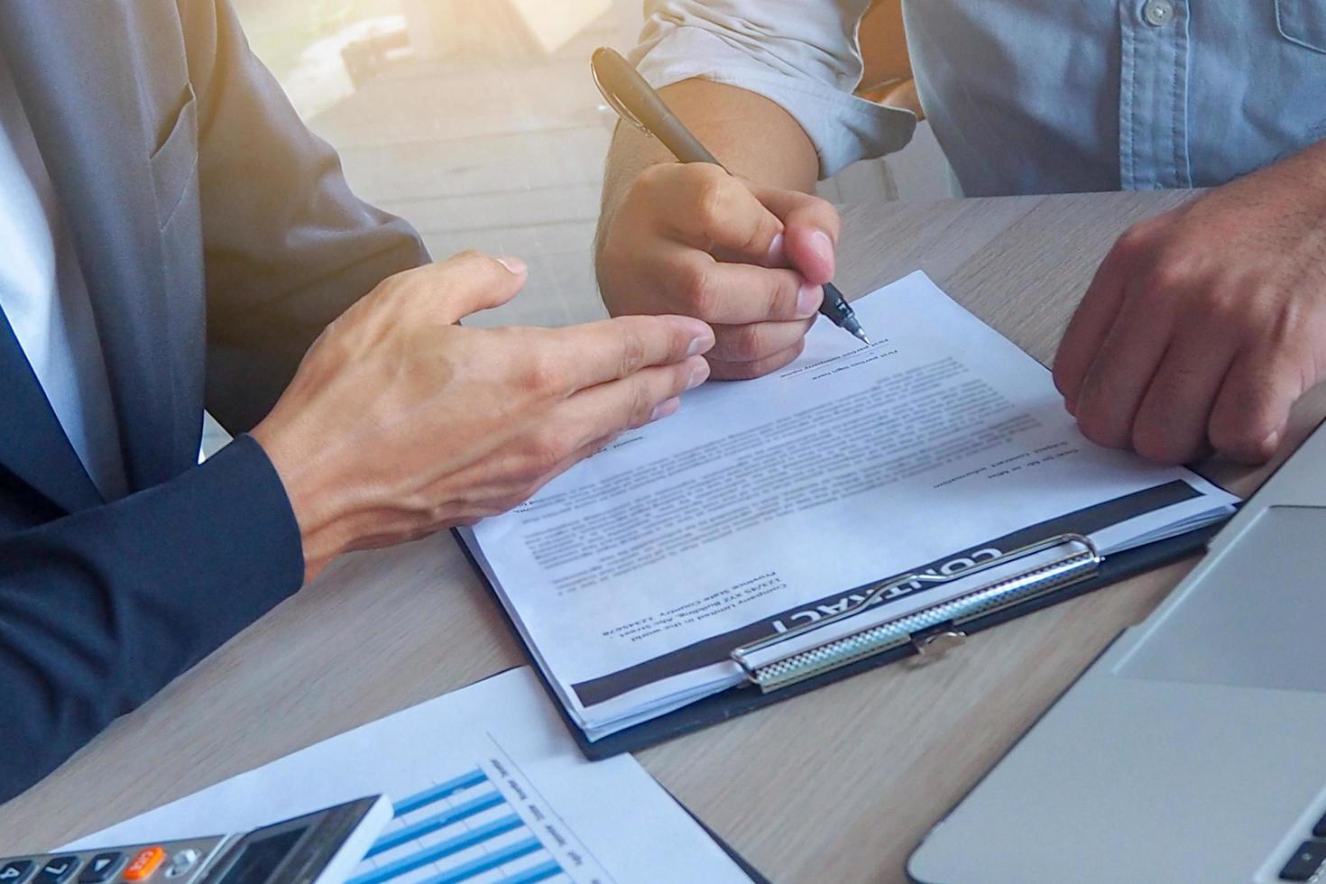 les hommes d'affaires montrent des gestes les invitant à signer un contrat commercial. la loi est efficace. signature du concept de contrat. photo