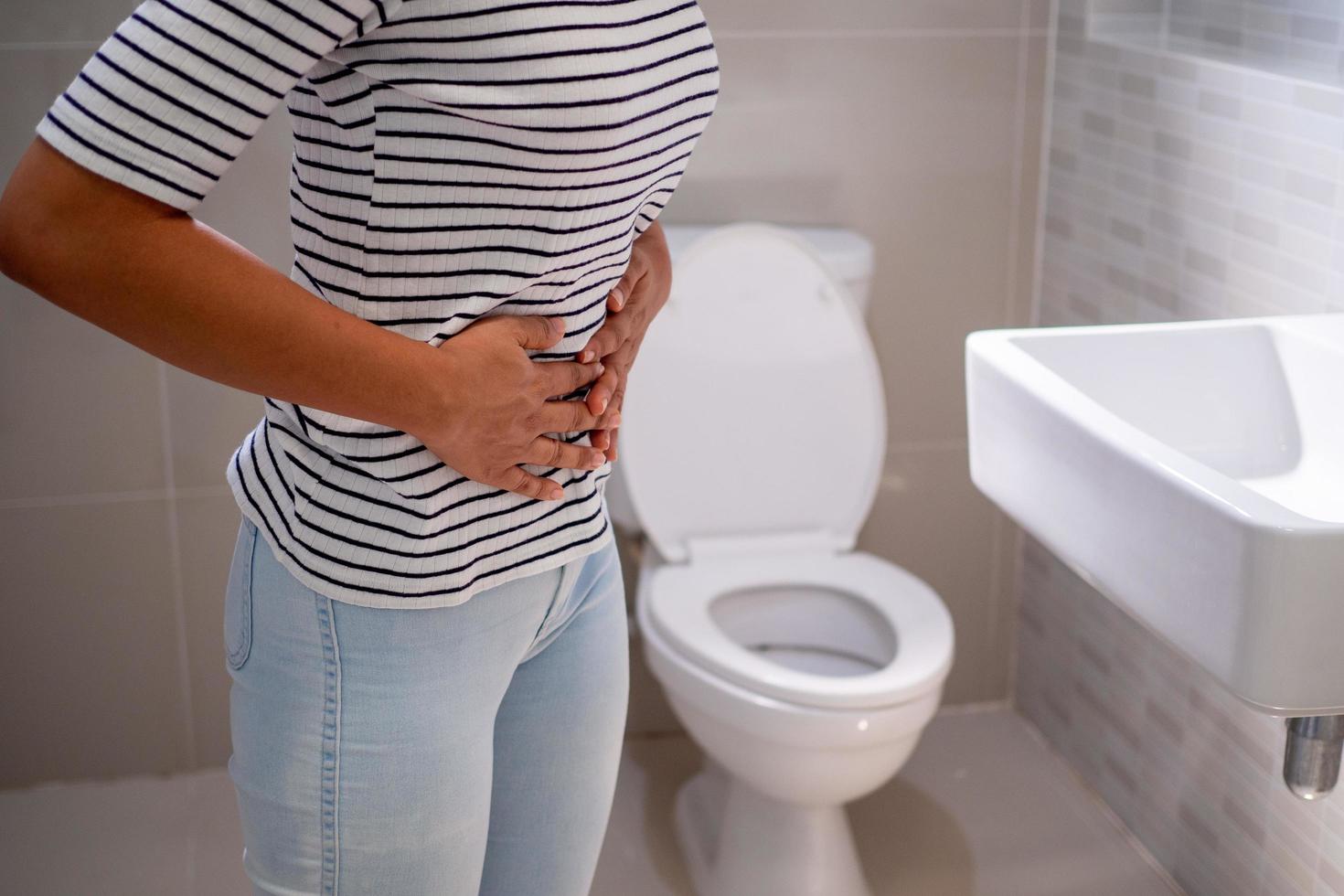 constipation et diarrhée dans la salle de bain. blesser la femme toucher le ventre mal de ventre douloureux. problème d'inflammation du côlon, aliments toxiques, douleurs abdominales, abdomen, toilettes constipées, maux de ventre, hygiène photo