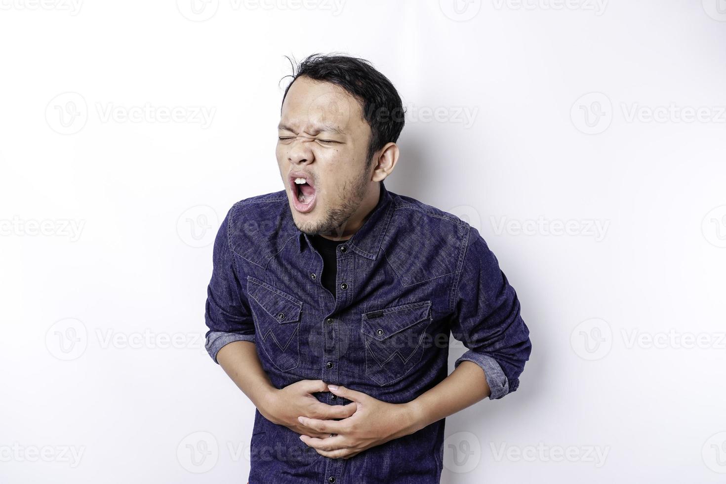 Photo d'un jeune homme malade malade malade tenir la main sur l'estomac souffre de douleur isolé sur fond blanc