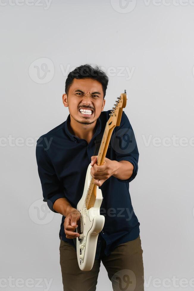 portrait de jeune homme asiatique en chemise bleue avec guitare électronique isolé sur fond blanc photo