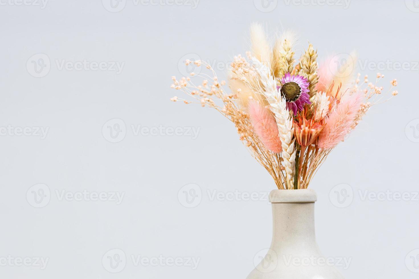 bouquet de plantes séchées dans le goulot d'une bouteille en céramique photo