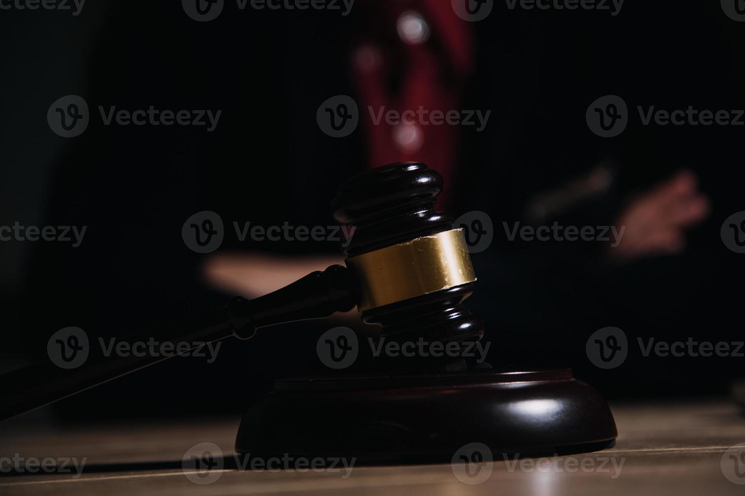 concept de justice et de droit. juge masculin dans une salle d'audience avec le marteau, travaillant avec, clavier d'ordinateur et d'accueil, lunettes, sur table à la lumière du matin photo