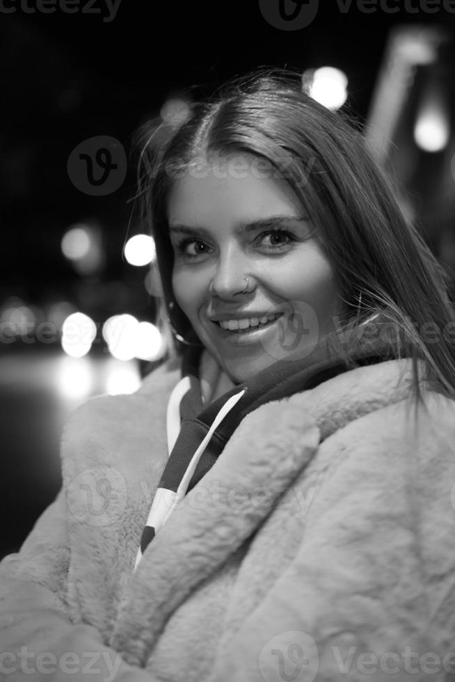 portrait noir et blanc d'une fille dans le contexte d'une ville nocturne photo