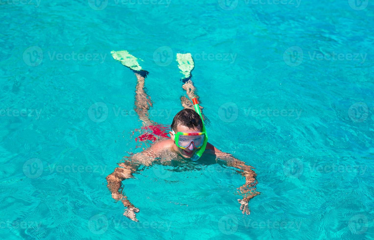 jeune homme plongée en apnée dans des eaux turquoises tropicales claires photo