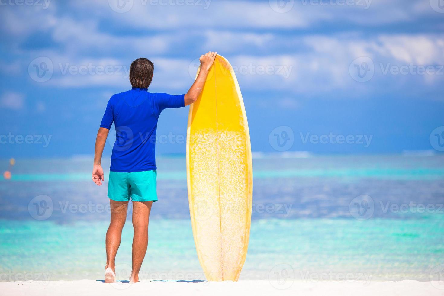 heureux jeune homme surfant sur la côte tropicale photo