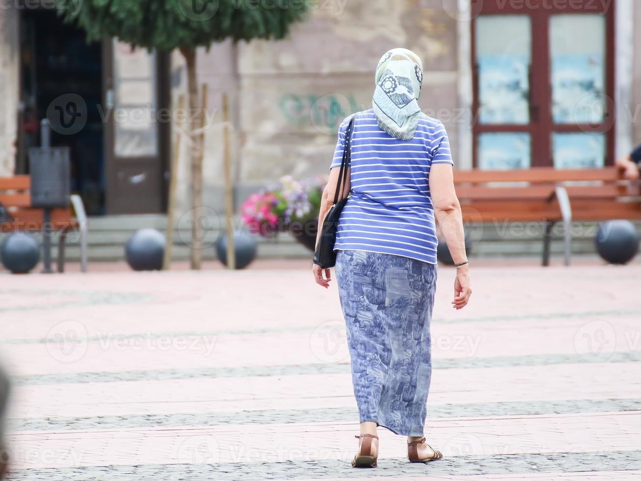 femme marchant dans la rue par une journée ensoleillée photo
