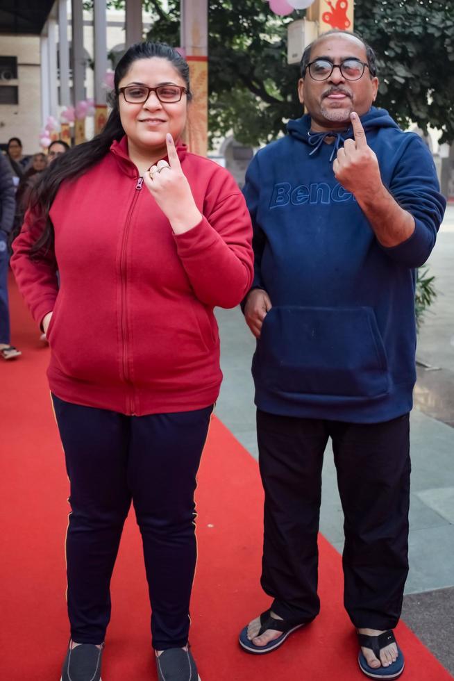 new delhi, inde - 04 décembre 2022 - des personnes non identifiées montrant leurs doigts marqués à l'encre après avoir voté devant le bureau de vote de la région de delhi est pour les élections locales mcd 2022 photo