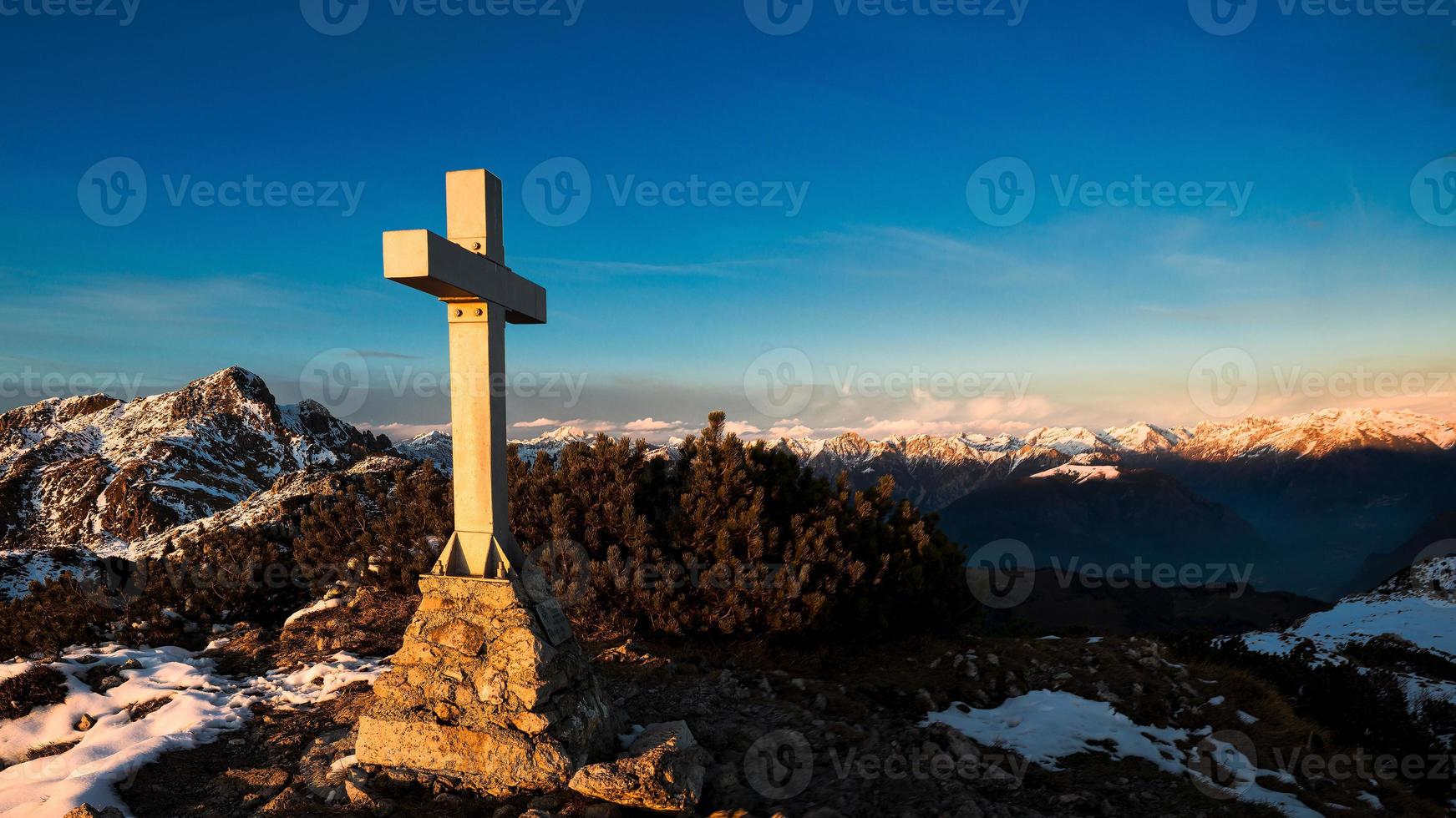 panorama de montagne depuis le sommet où une croix est placée photo