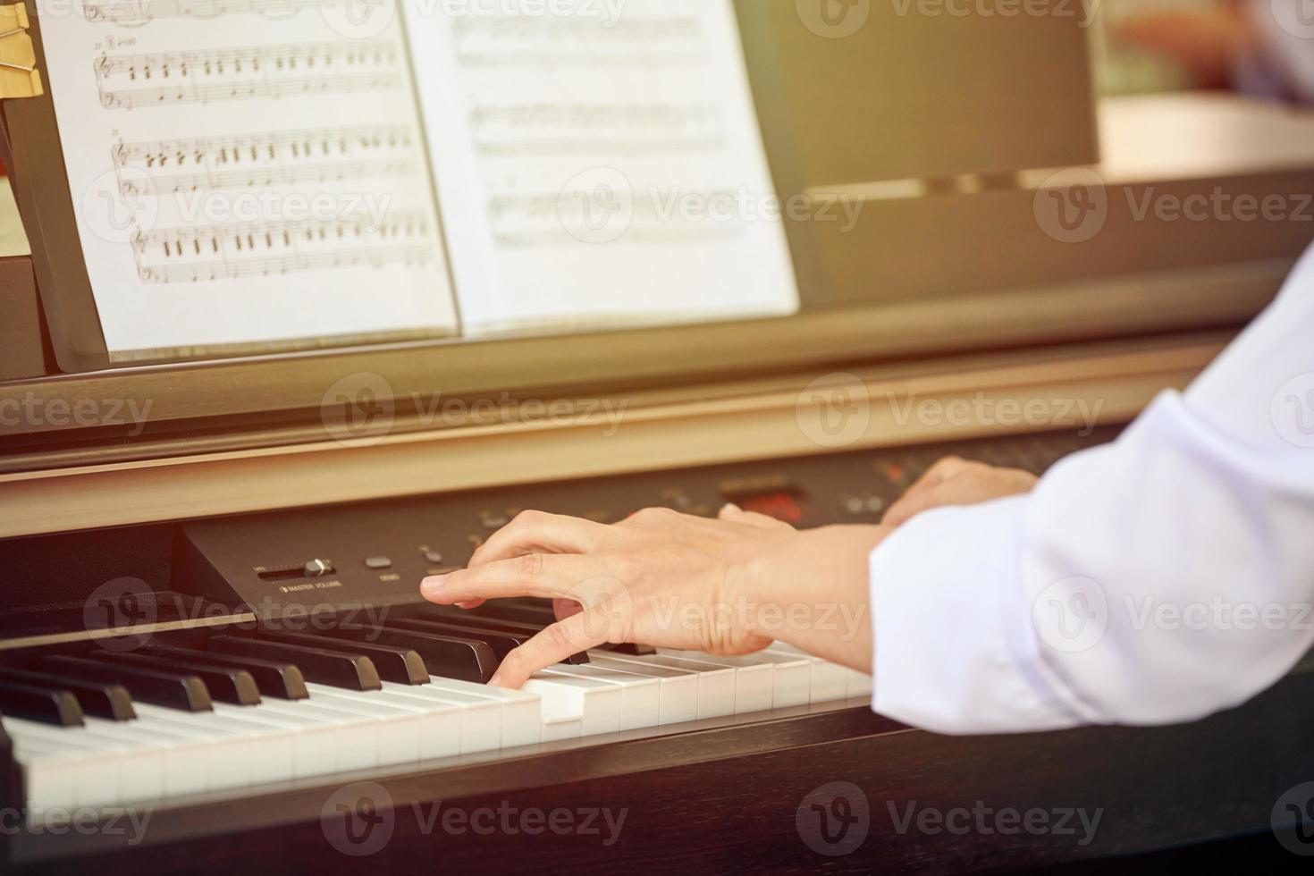 une femme joue du piano électrique lors d'un spectacle de musique en plein air, vue rapprochée sur des mains agiles photo