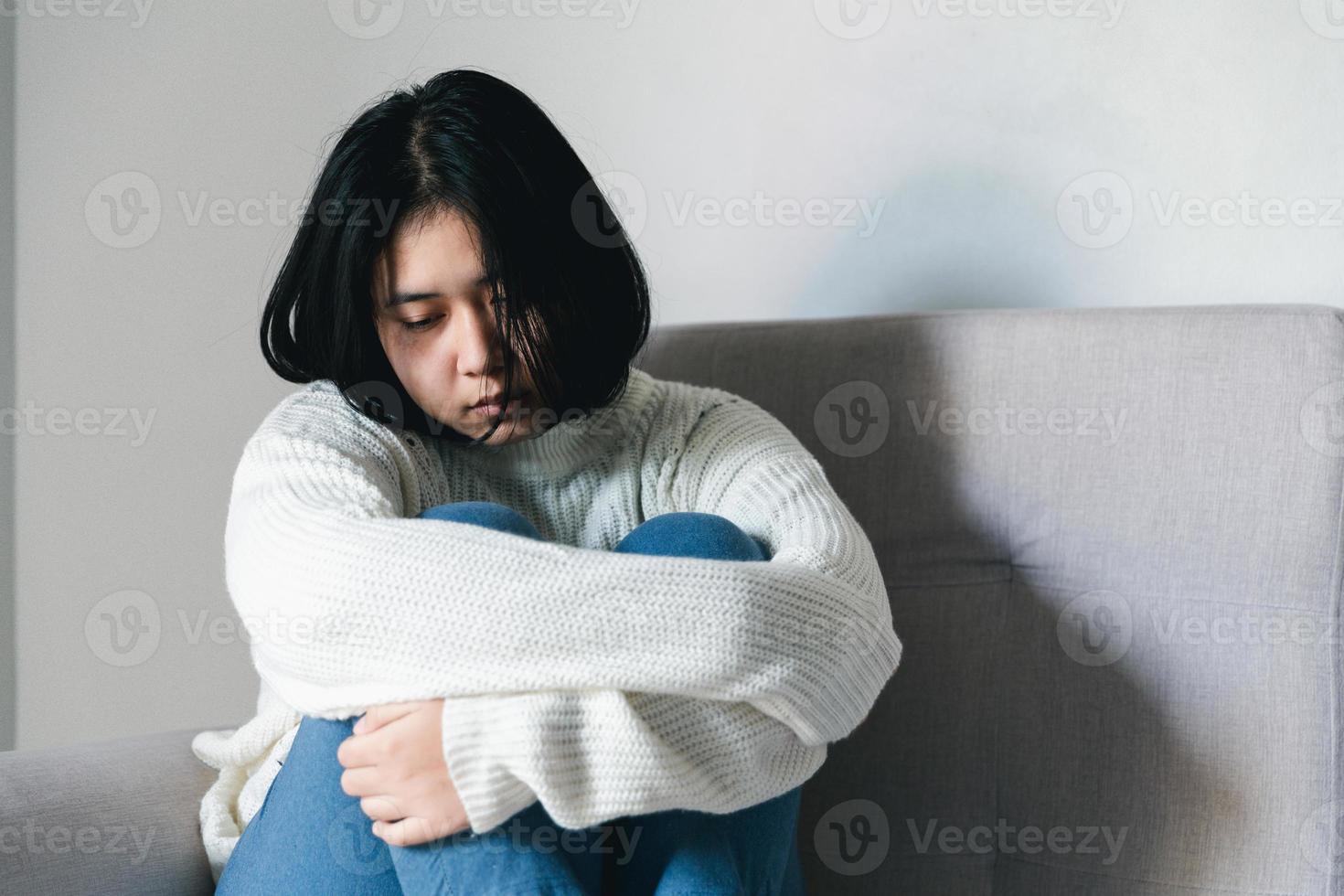 concept de triste dépression adolescente. adolescente bouleversée assise à la fenêtre à l'intérieur. anxiété jeune femme désespoir et stress. les femmes seules et malheureuses sont des victimes sociales. jeunesse de solitude à la maison. photo