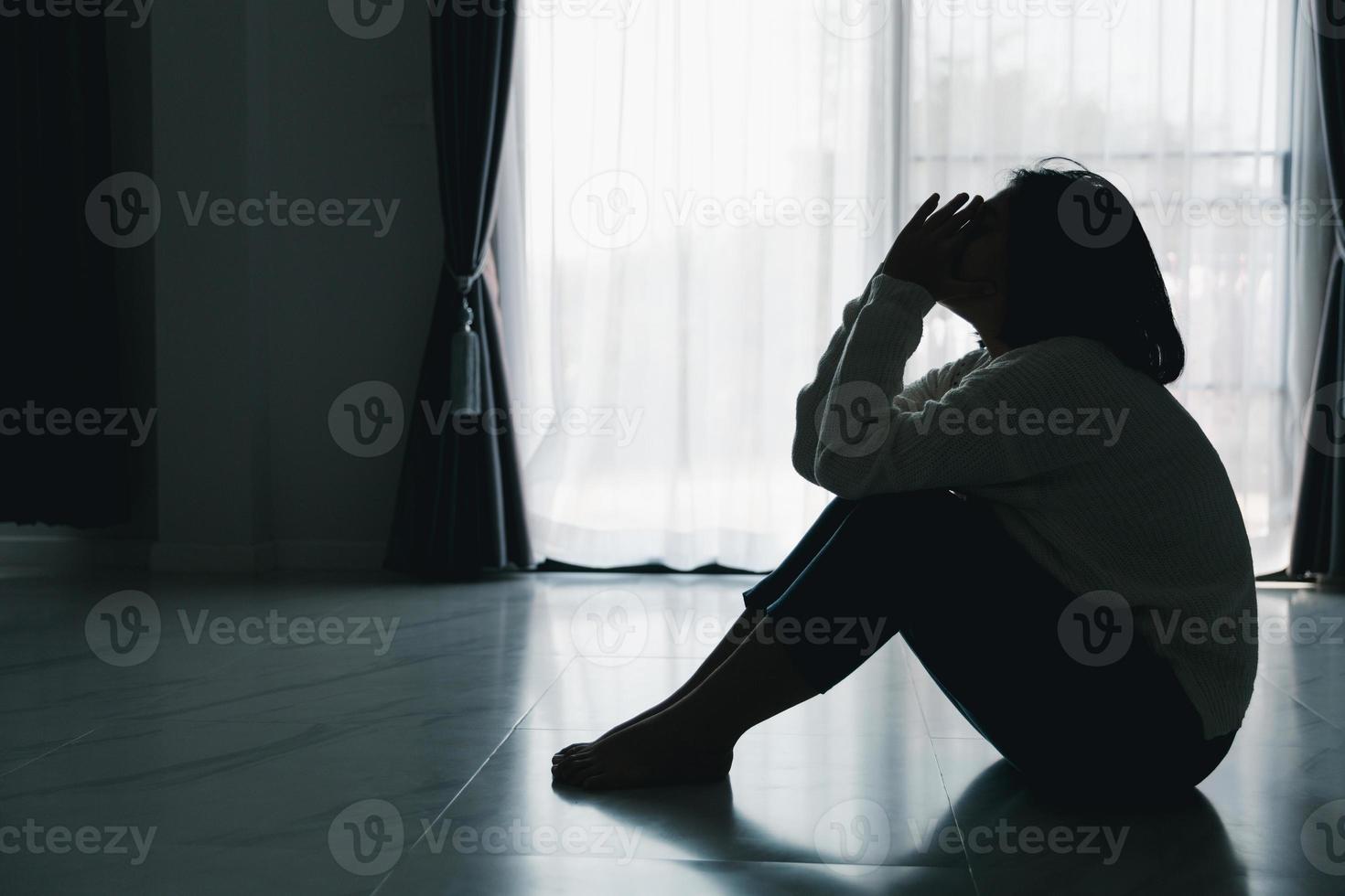 concept de triste dépression adolescente. adolescente bouleversée assise au sol à l'intérieur. anxiété jeune femme désespoir et stress. les femmes seules et malheureuses sont des victimes sociales. jeunesse de solitude à la maison. photo