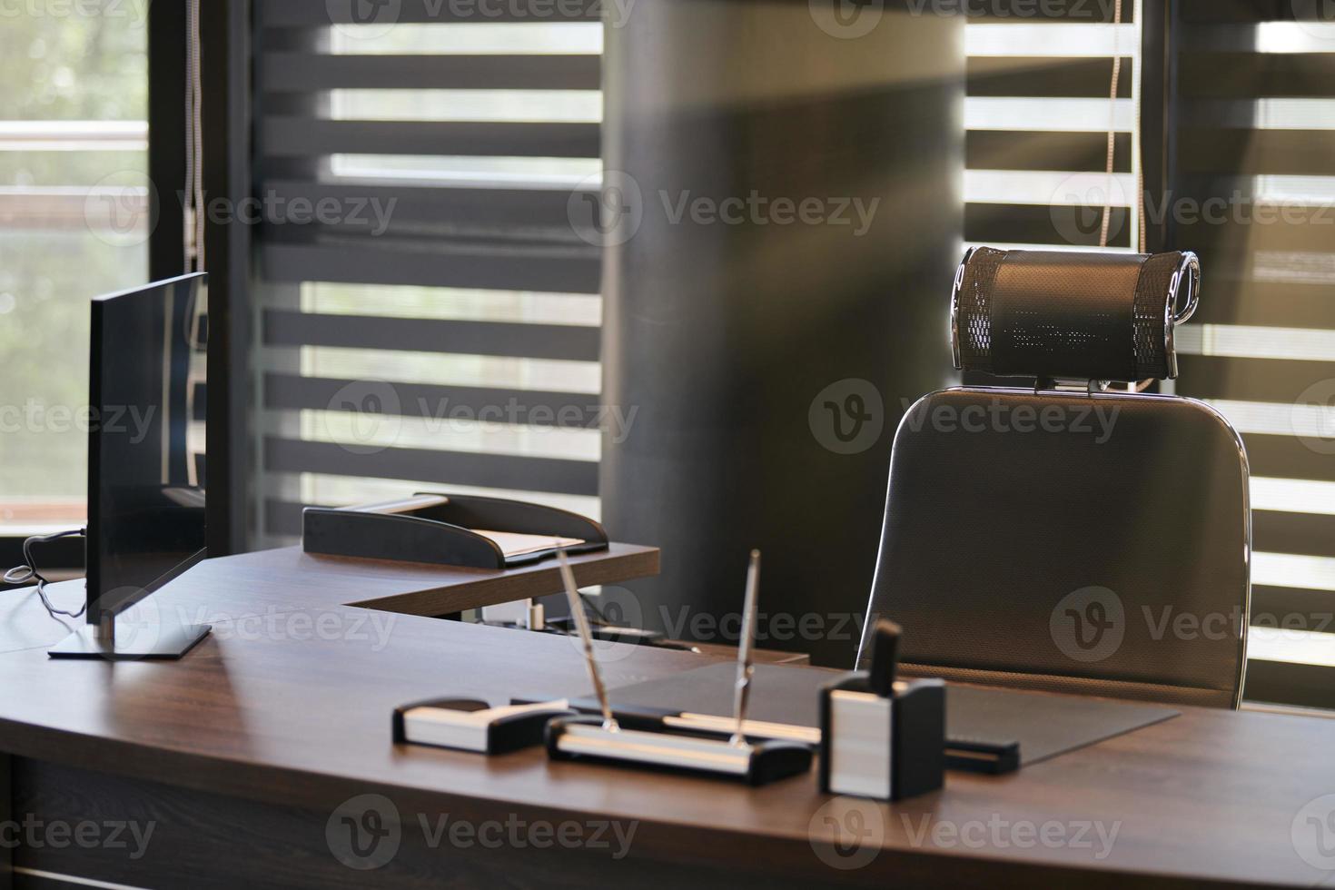 lieu de travail de bureau d'affaires. la lumière du soleil sur le lieu de travail pour le chef, le patron ou d'autres employés. table et chaise confortable. lumière à travers les stores à demi ouverts photo