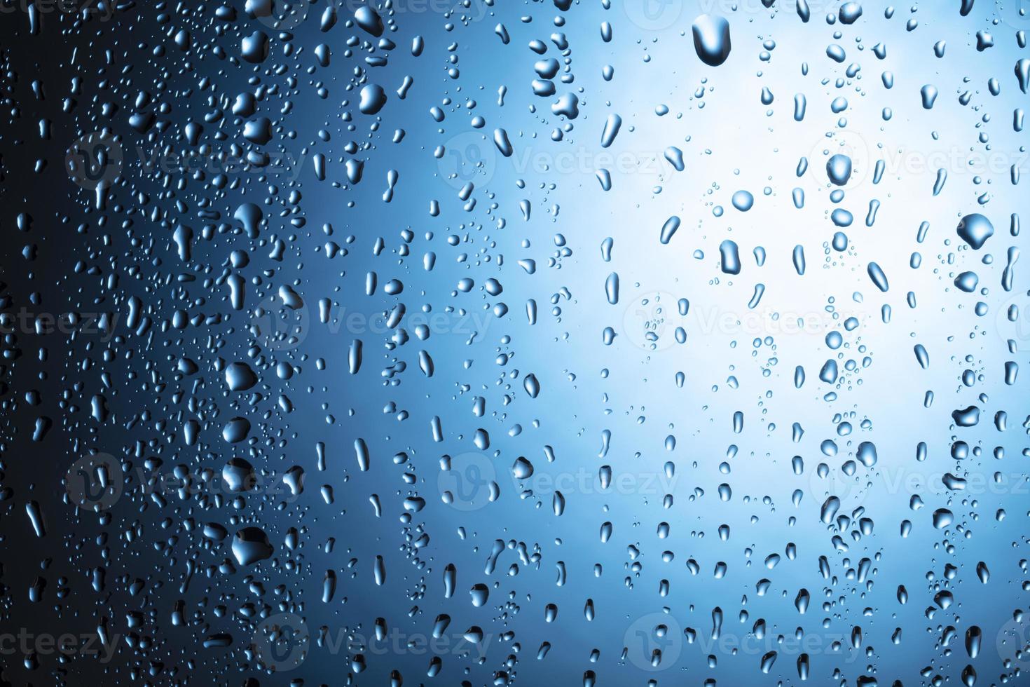 gouttes d'eau en gros plan sur un fond de verre bleu. photo