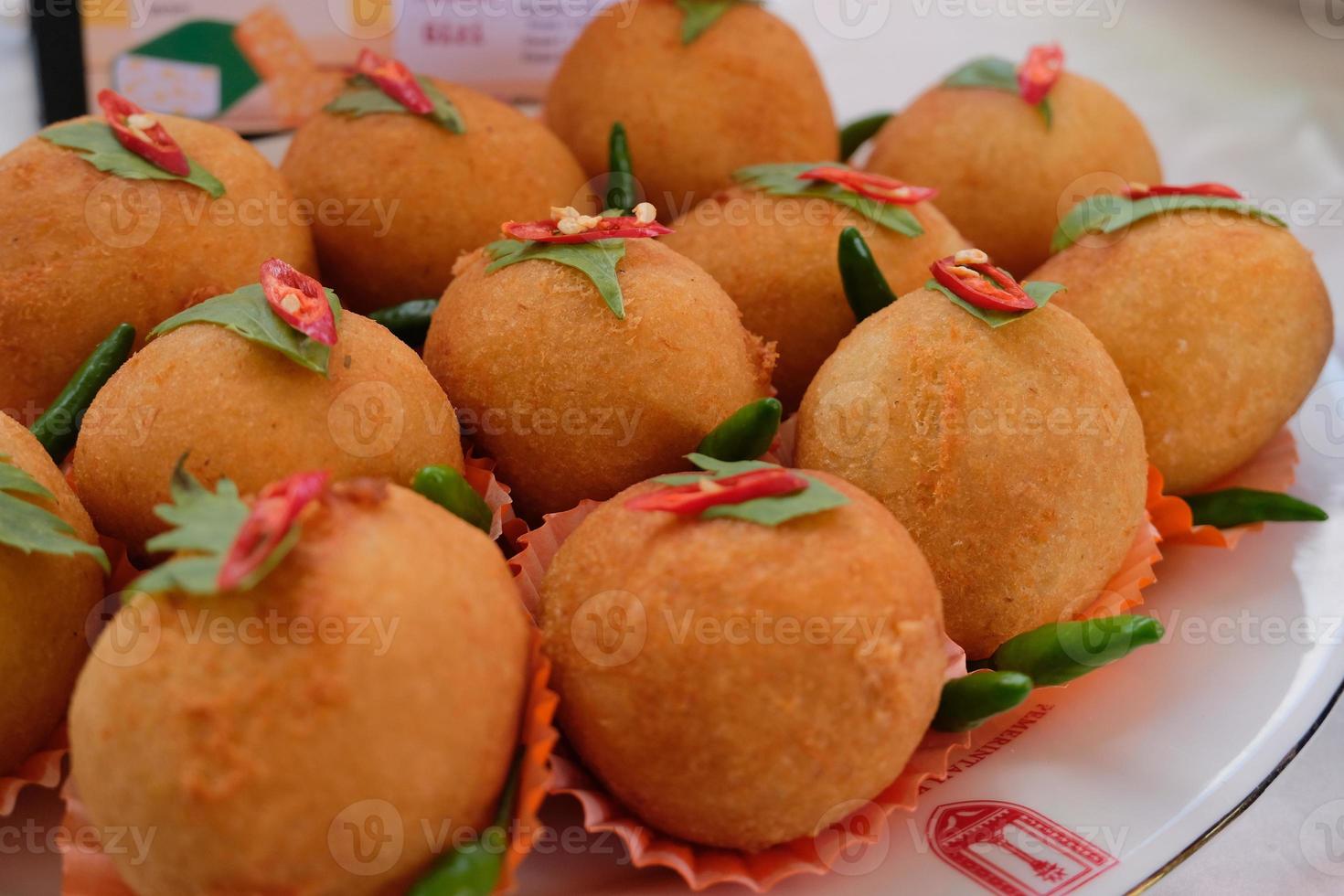 kroket kentang est une collation traditionnelle d'indonésie. servi dans une assiette en bois avec du piment vert. délicieux kroket kentang traditionnel indonésien au piment photo